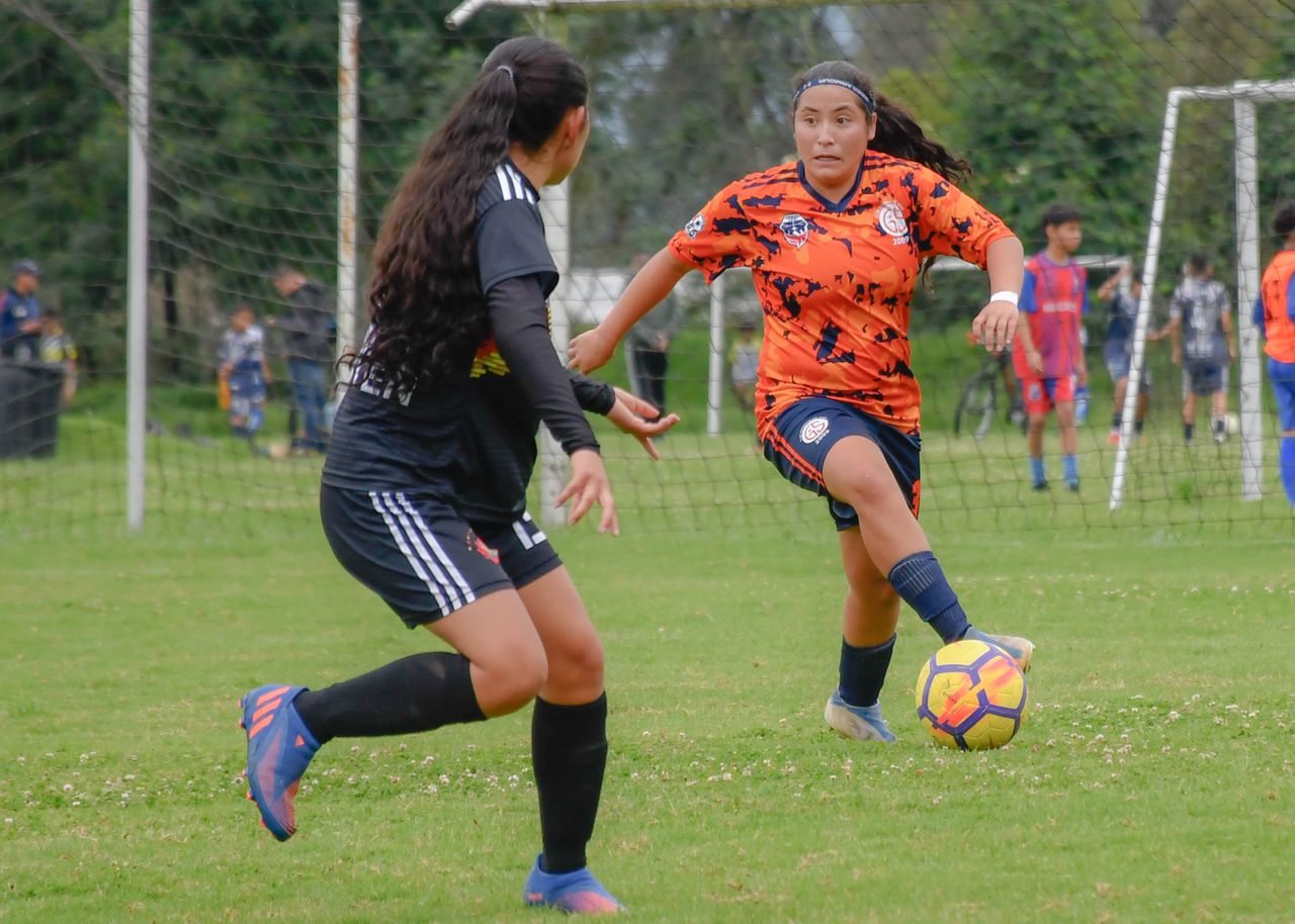 Mastering the First Impression: Your intriguing post title goes here Two women engaged in an outdoor soccer match, showcasing competitive play on a grassy field.